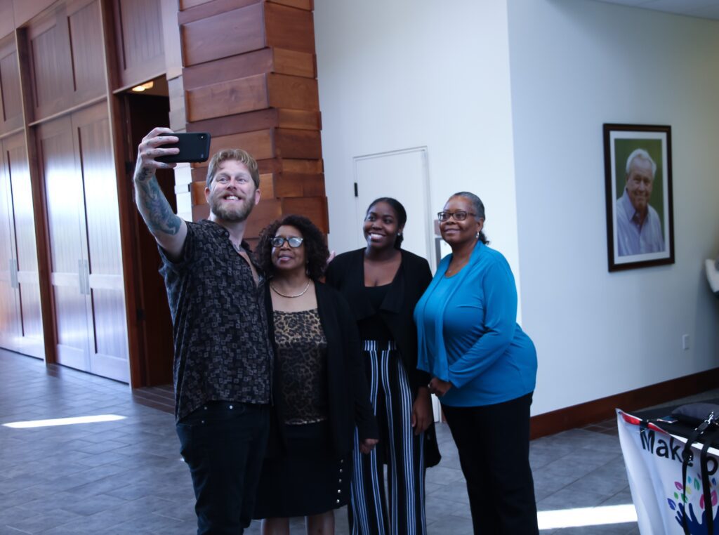 Arno a blond white man taking a selfie with three black women