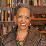 Dr. Johnnetta Cole, a Black woman with short salt and pepper hair wearing a patterned brown jacket