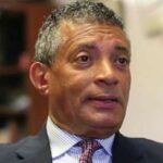 Tim Stevens head shot, a black man with salt and pepper hair wearing a dark gray suit